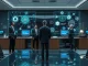 BNY Mellon and Goldman Sachs executives shake hands over a digital display, symbolizing the blockchain tokenization of money market funds.