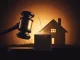 A gavel striking a block with blockchain symbols and a cracked house, representing the RealT lawsuit and its impact on RWA market viability.