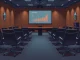 Empty boardroom chairs and a projector screen, symbolizing Bit Digital's failed ETH purchase new shares vote due to a lack of quorum at the shareholders' meeting.