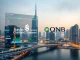 Standard Chartered and QNB Group logos overlaying a digital finance interface in Dubai, symbolizing the launch of the first tokenized MMF in DIFC.
