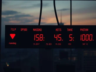 A visual representation of the US stock indices showing a lower opening, with red arrows pointing down on a digital display, highlighting the S&P 500, Nasdaq, and Dow Jones.