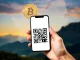 A smartphone screen showing a QR code for payments, representing ScanToPay's new South Africa crypto payments integration.