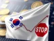 Illustration of South Korean regulators halting **spot crypto ETF** trading, depicting financial symbols and a regulatory block.