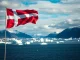 Danish flag flying over Greenland's landscape symbolizing Denmark's sovereignty commitment