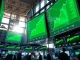 Trading floor displays showing major US stock indices opening higher with green charts