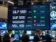 A trading floor data screen shows US stock indices with mixed results for S&P 500, Nasdaq, and Dow Jones.