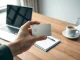 Essential AI notetaking device for recording and transcribing professional meetings on a desk.