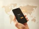 Bitget Wallet enables global stablecoin mobile top-ups via DT One partnership on a smartphone interface.