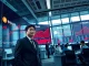 Regulator at Bithumb crypto exchange in Seoul reviewing compliance issues on trading floor display.