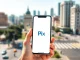 Smartphone displaying Brazil's Pix instant payment system interface in an urban setting connecting São Paulo and Buenos Aires.