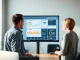 Financial professionals review an AI-powered loan origination dashboard at a credit union.