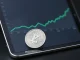 Litecoin price prediction analysis showing a silver LTC token and a financial trend chart.
