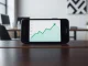 Robinhood app on a smartphone showing a stock chart, representing the company's financial strategy and market activity.