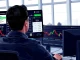 Trader analyzing prediction market data and crypto charts for real-time geopolitical risk assessment.