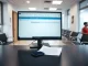 Medical office reception desk with a computer showing a digital referral processing interface and a smartphone next to a paper document.