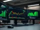 Bitcoin price chart showing dip below $80,000 with ETF inflow data on trading monitors
