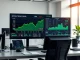 Financial trading desk with Bitcoin price chart showing recovery above $80,000