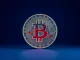 Bitcoin coin with internal graph showing a bearish trend for cryptocurrency market analysis.