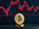 Bitcoin coin on a red digital chart showing overbought market conditions