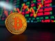 Bitcoin coin in foreground with blurred financial market data background