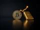 Bitcoin coin and gold bar on reflective surface with subtle graph lines
