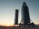 Cowboy Space rocket on launch pad at dawn with data center equipment visible inside second stage