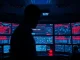 Cybersecurity analyst monitoring crypto hack alerts on multiple screens in a dark operations center.