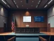 Empty courtroom with blockchain data on screen representing crypto legal news