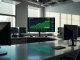 Newsroom monitors showing Bitcoin price charts at $80,000 and financial data
