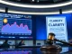 Newsroom display showing Bitcoin price chart and CLARITY Act document with gavel