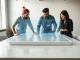 Team collaborating around a holographic design and code interface in a modern startup office
