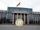 German Finance Ministry building in Berlin with a Bitcoin coin in the foreground symbolizing potential tax changes.