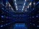 Interior of a modern data center with GPU servers and blue lighting, representing AI infrastructure investment.