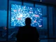 Digital screen showing blockchain transaction network with red flagged nodes in a dimly lit surveillance office.