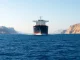 Oil tanker navigating the Strait of Hormuz as Polymarket odds for normalized traffic spike.