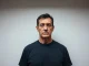 Keonne Rodriguez, Samourai Wallet co-founder, with a serious expression in a booking-style photo