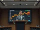 Michael Saylor at a Strategy earnings presentation with a Bitcoin chart on screen