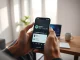 Person holding smartphone showing Spotify app with AI-generated personal podcast playlist