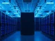 Interior of a large data center with rows of server racks and blue lighting