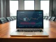 Laptop displaying Ethereum charts and wallet balance in a professional boardroom setting