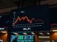 WLFI token price chart showing a sharp decline on a digital display in a dimly lit trading room
