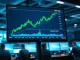 Professional trading desk with monitor displaying XRP price chart showing an upward trend