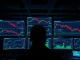 Bitcoin price charts and options data displayed on trading monitors in a dimly lit financial trading desk environment.