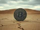 A weathered Bitcoin coin on a cracked desert floor, symbolizing the challenges facing Bitcoin DeFi.