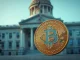 Bitcoin coin in foreground with blurred government building and American flag in background