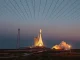 SpaceX Starship rocket launching at dusk with orbital satellite array visible in space above