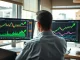 Financial analyst reviewing Bitcoin price charts on multiple screens in a modern office