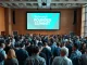 Crowd of founders and investors networking at TechCrunch Founder Summit conference hall with keynote stage.