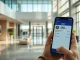 Traveler holding a smartphone showing a USDC payment confirmation in a modern hotel lobby