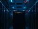 A dimly lit data center aisle with a single 'Mechanical Turk' server rack showing an amber status light, symbolizing the service's reduced operations.